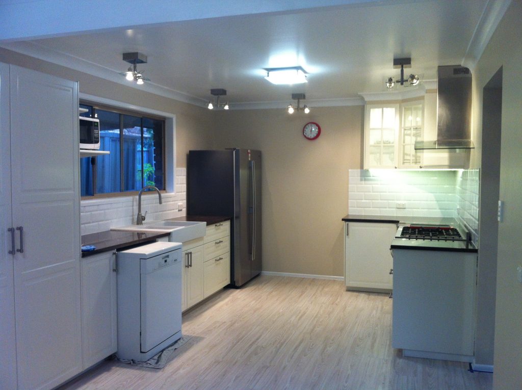 Renovated kitchen with white cabinetry and stainless steel appliances